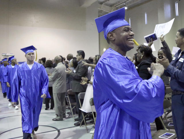 In this photo taken Dec. 12, 2014 shows inmates, in caps and gowns in the Prison Entrepreneurship Program marching toward the stage for graduation ceremonies, at the Cleveland Correctional Facility in Cleveland, Texas. The Prison Entrepreneurship Program, or PEP, is based on a philosophy that making inmates like Chavez business savvy will reduce the likelihood that theyll end up back in prison. It emphasizes reforming behavior while also working on a broader goal of reducing the prison population. (AP Photo/Pat Sullivan)